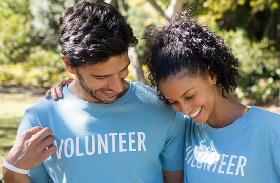 man and woman outside in shirts that say "volunteer"