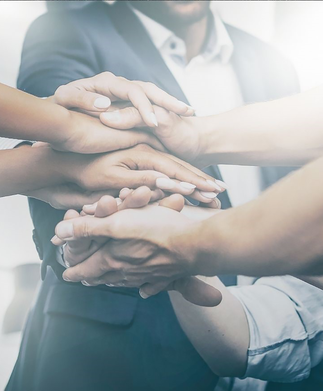 coworkers in a huddle with hands stacked on top of each other