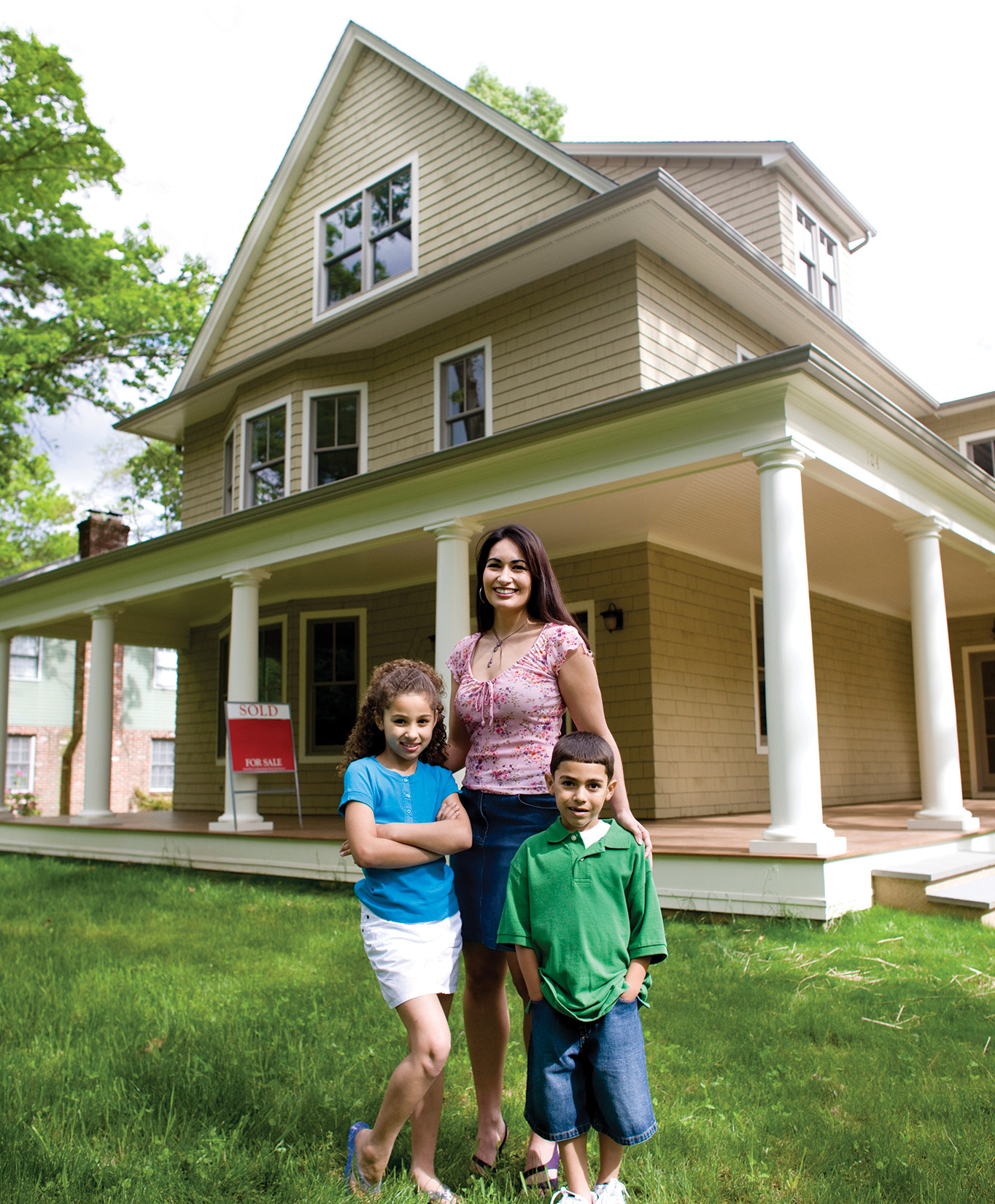 mother with her 2 children in the front yard of their home