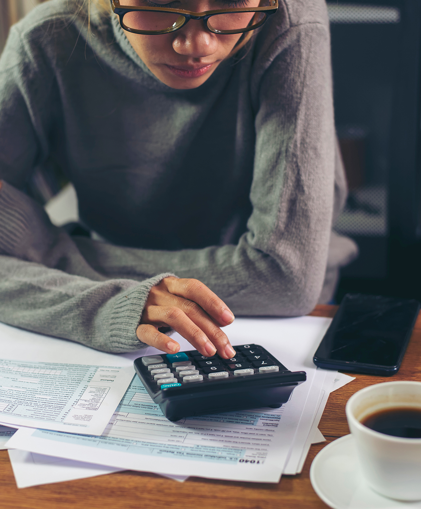 person working on their taxes with a calculator