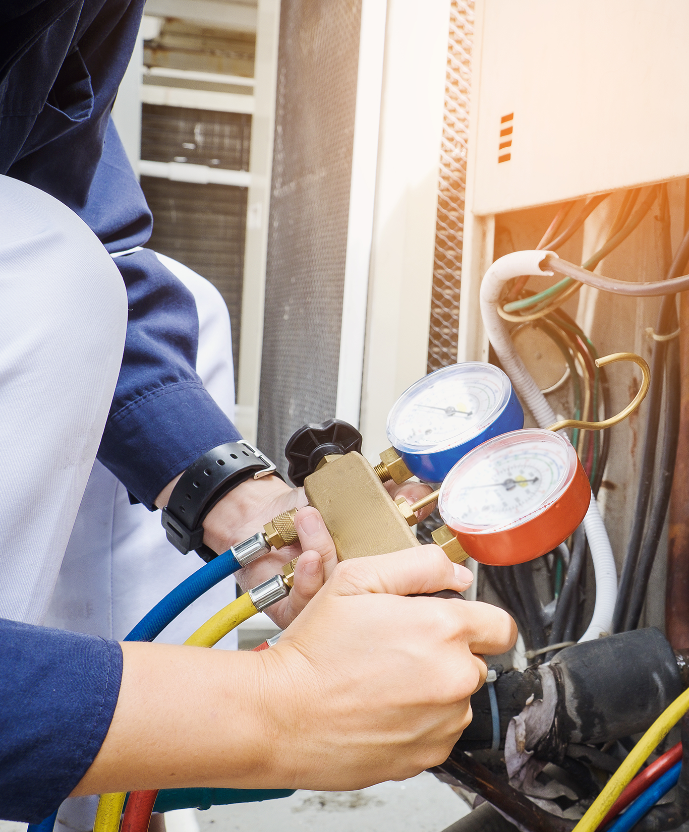 Worker looking at gauges while fixing a furnace
