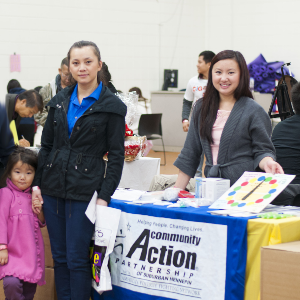 CAPSH staff member poses with community members at 2012 Hmong Resource Fair outreach event