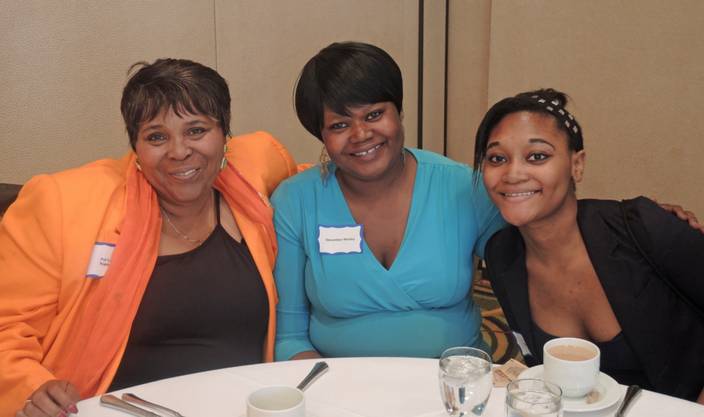 3 staff members smiling for a photo at the 2015 Annual Meeting Luncheon