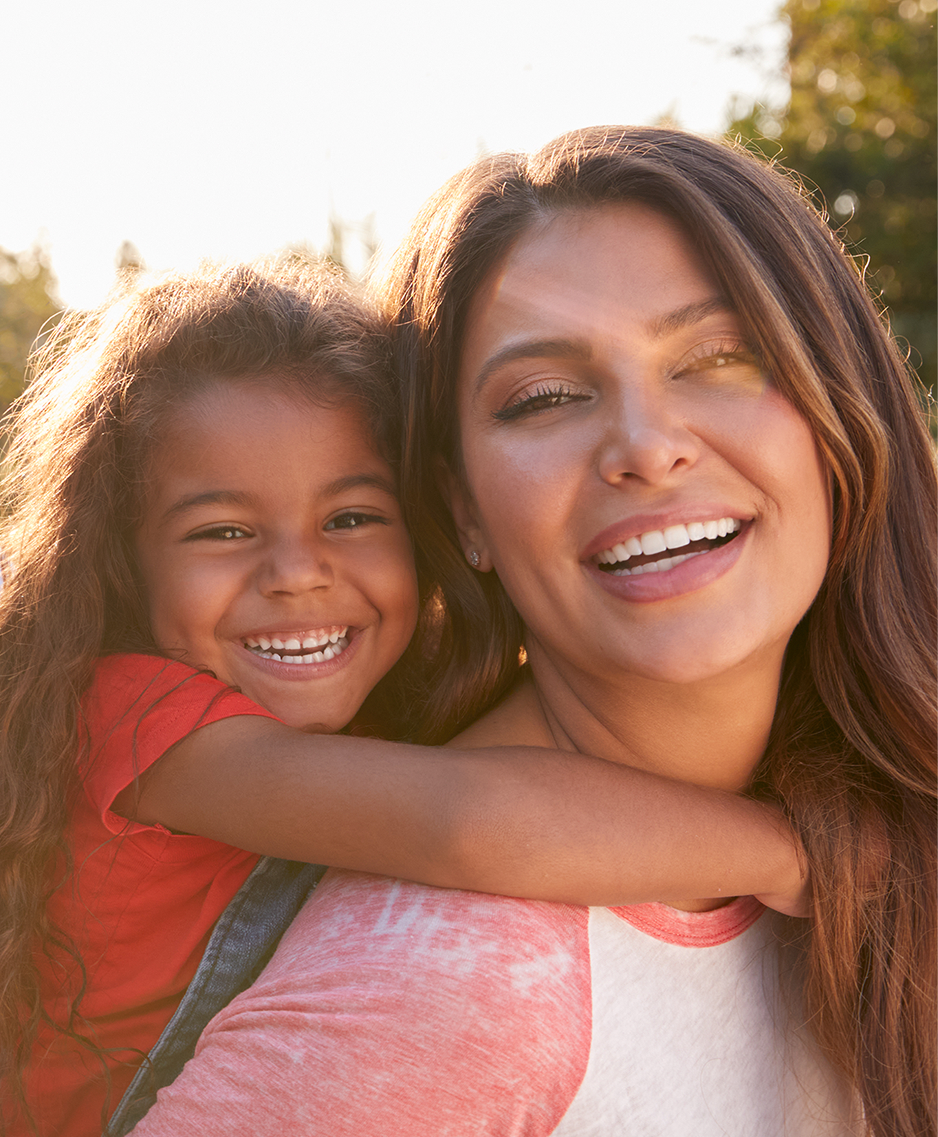 smiling daughter and mother outside at sunset