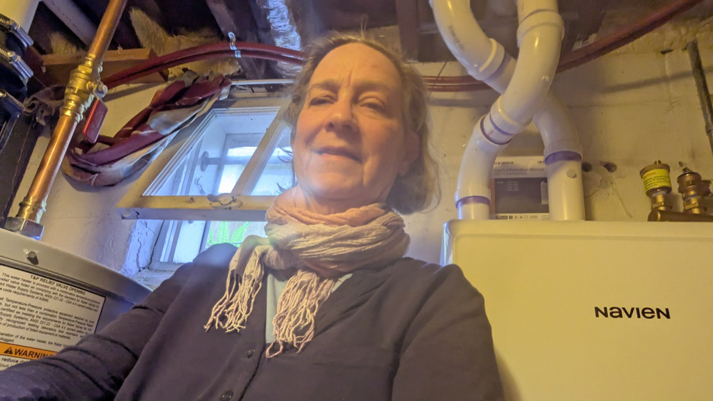 Sharee, 2025 Energy Assistance and Energy-Related Repair client,
standing between her new boiler and water heater