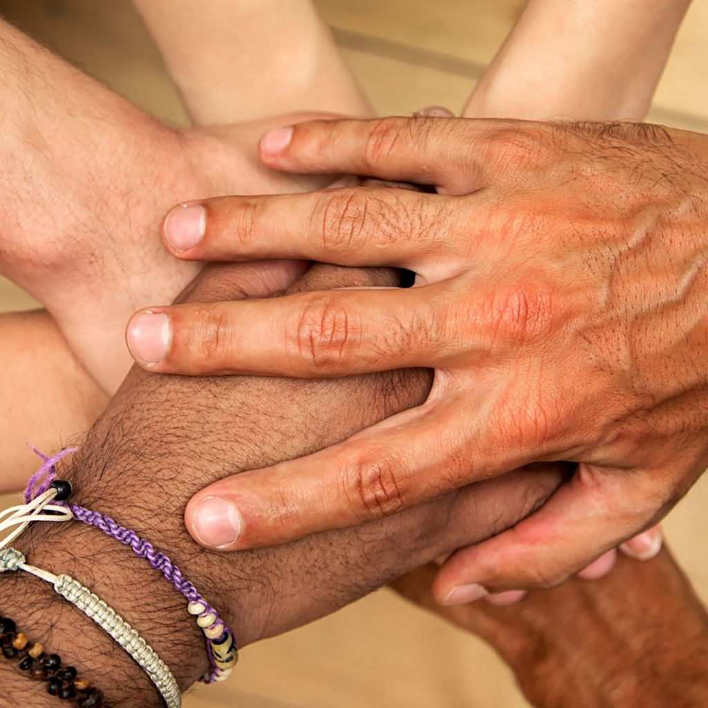 close up of stacked hands as seen from above
